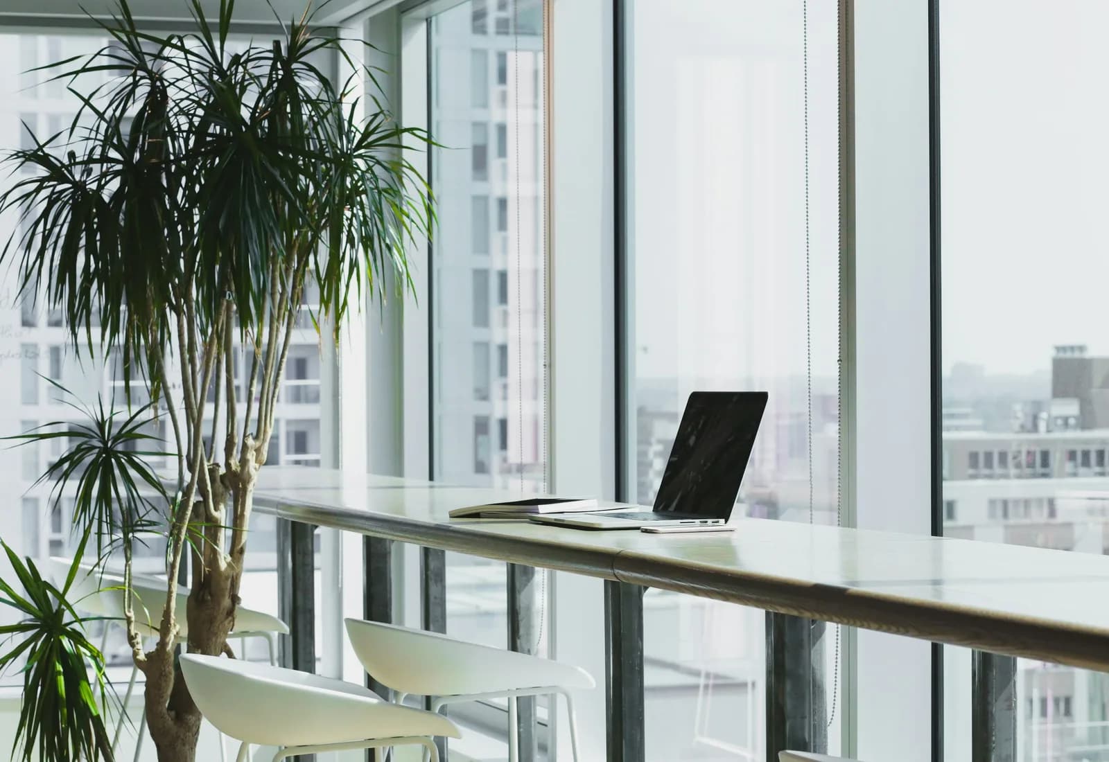 A laptop on a desk in a bright, open-plan office